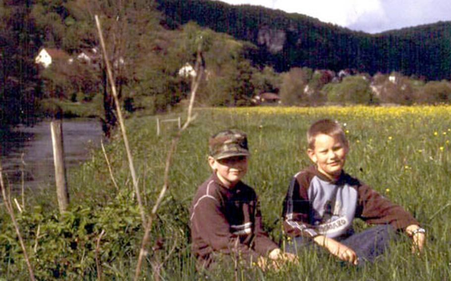 Florian, left, and Oliver pose for a photo in a meadow along the Wiesent River. Like many children, they like to watch anglers fish and are happy to help free the fish after they are caught.