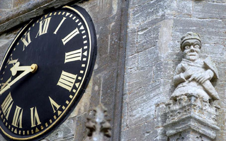 The church clock is protected by a wide-eyed guardian carved in stone.