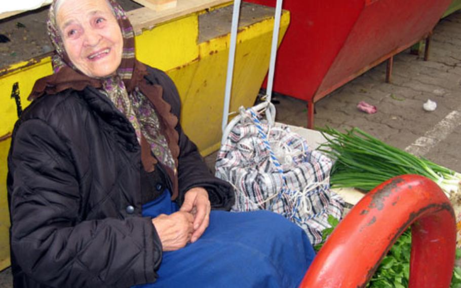 A vendor sits with her onions and other fresh produce at an outdoor market in Sofia. Fresh breads, cheeses, fish, clothing and handmade tools were all available at the market.