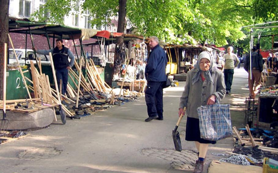 With a newly-purchased shovel in hand, a woman walks past stalls selling hand-made tools in Sofia, Bulgaria.
