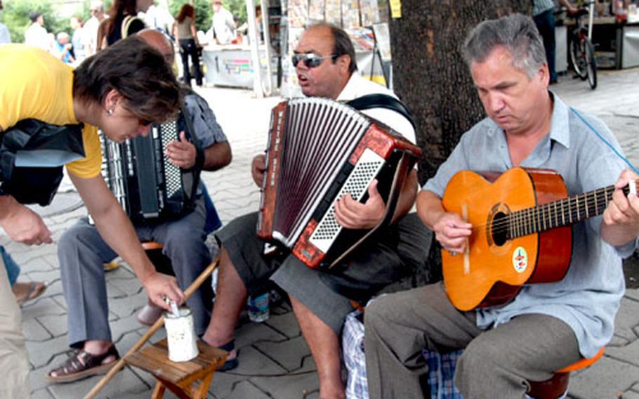 Streetside musicians perform in downtown Sofia near the bustling open-air market. Walking the streets of Sofia is a tour of the unpredictable. Stray animals are common, as are businessmen and politicians in pressed suits.