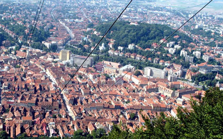 From a cable car, an impressive view of the tidy city of Brasov in the heart of Romania. Tourists often come here on their way to the Carpathian Mountains.
