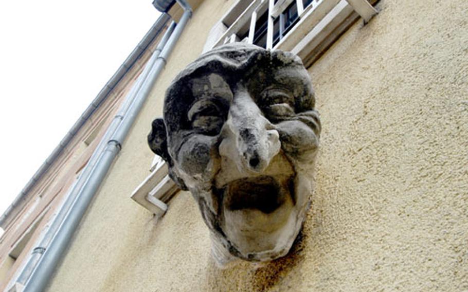 A strange head statue stands above a doorway in Luxembourg&#39;s old town.