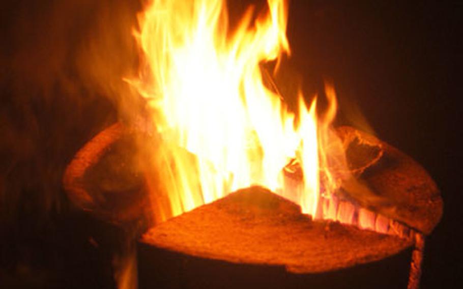 Flames leap high from a “Sweden torch” made from a pine trunk. They are familiar sights at the Romantic Christmas Market, providing heat and light for the palace grounds.