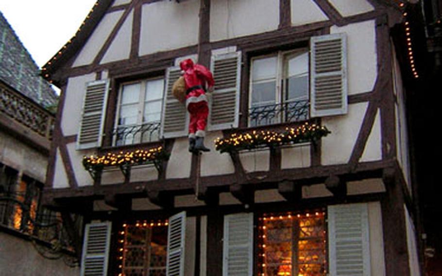 Père Noel scales one of the half-timbered houses near Colmar’s old custom house. The town’s Christmas market is held at six sites, including the custom house.