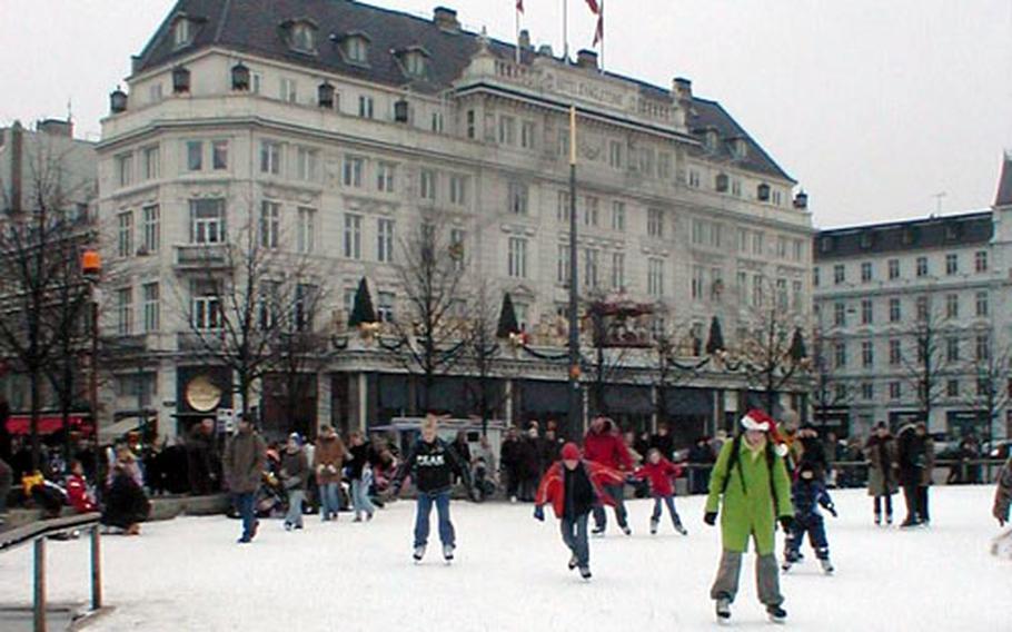 Skaters at KongensNytorv enjoy a turn on the ice. In the background is the Hotel D&#39;Angleterre.