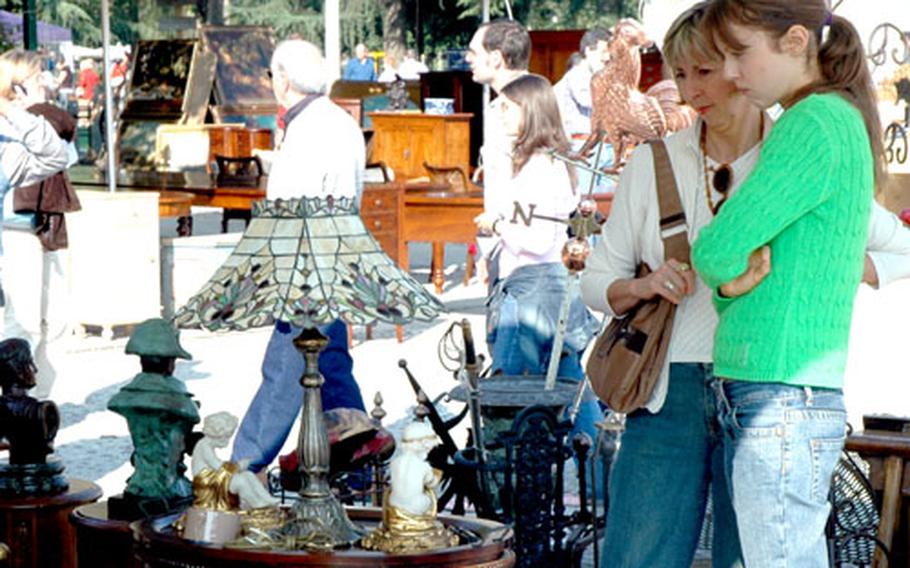 Elena and Stephanie examine a lamp at Piazzola sul Brenta&#39;s outdoor market. The vendor originally refused to negotiate on the price, but later in the day agreed to come down to the Jeans&#39; offer.