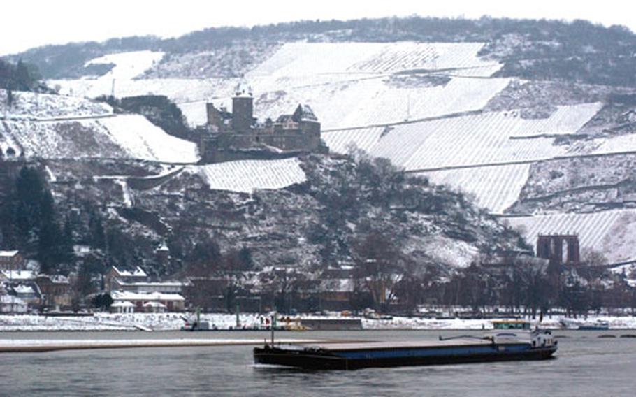 A Rhine River barge passes the picturesque town of Bacharach, Germany, dominated by Stahleck Castle, now a youth hostel.