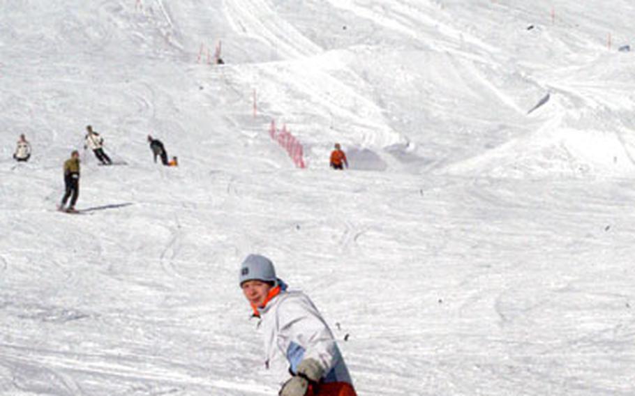 A snowboarder comes down one of the wide-open slopes at the ski resort at Feldberg, Germany. The chairlift in the background goes to the top of Seebuck peak.