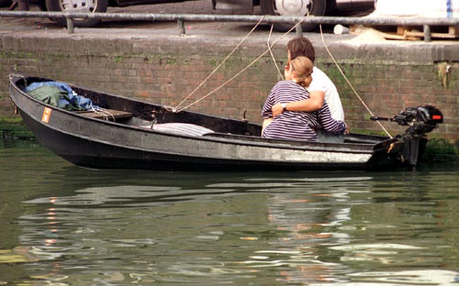 A couple enjoys a romantic moment in Amsterdam, a city of canals and lovely old bridges. Walk halfway across a bridge and pause for a lingering kiss. Then find another and repeat.