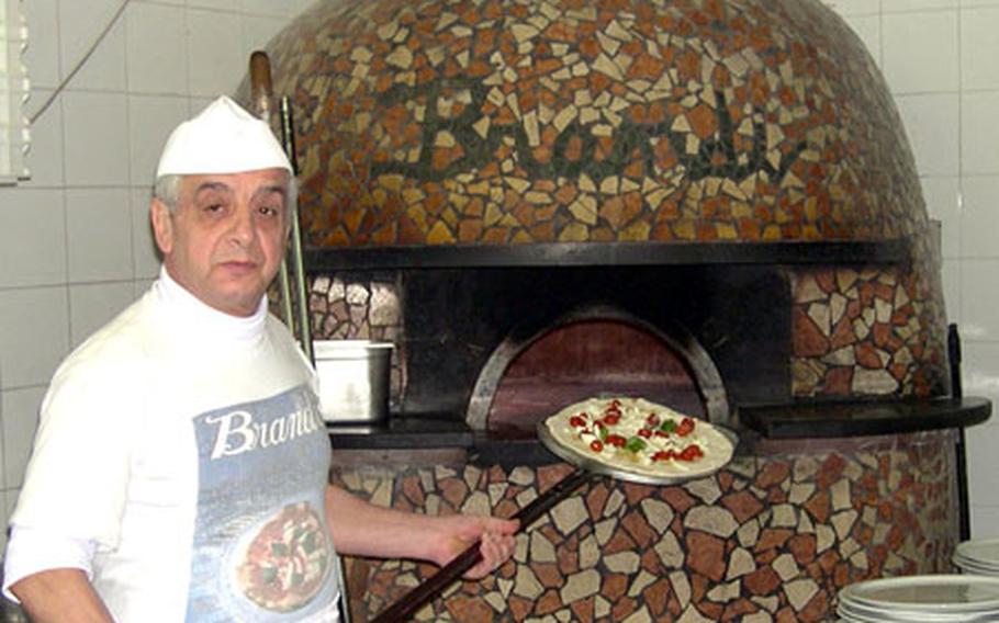 A chef prepares to put another pizza in one of the two ovens at the Brandi Pizzeria. The restaurant, where the Margherita pizza was named, has been in the same location since 1790.