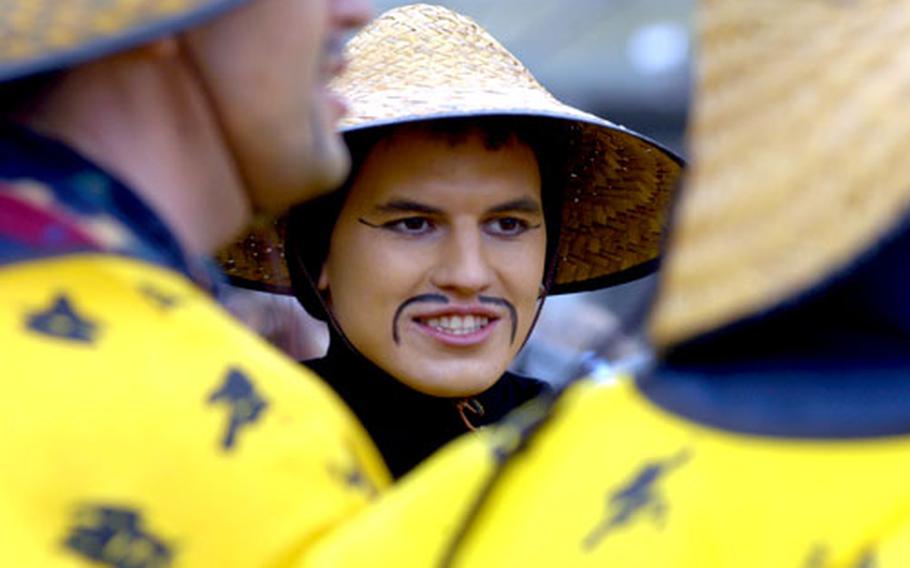 A member of a group of Chinese-themed revelers gets ready to sing on a main street in Dietfurt, Germany, after last year’s Chinesenfasching parade.