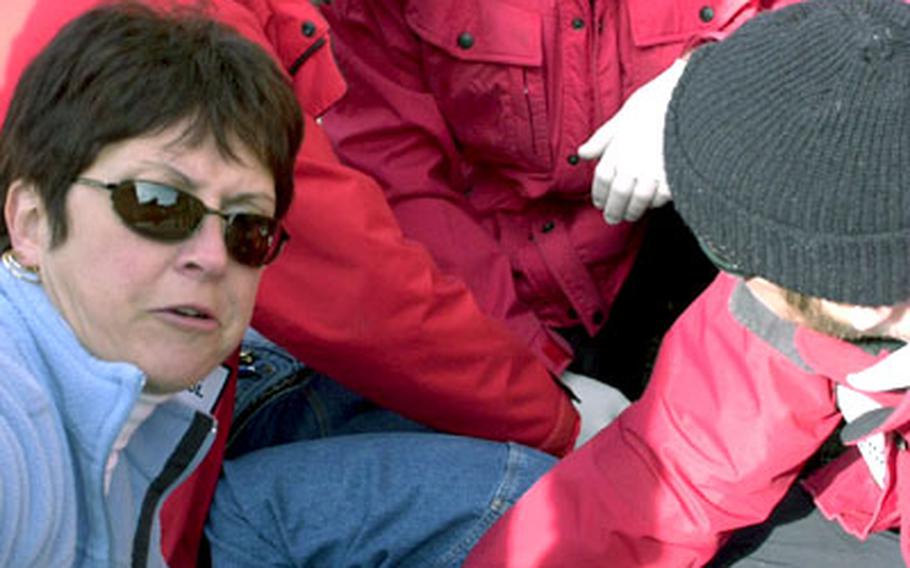 Ski patrol volunteers must attend classes twice a week for three months and complete an on-the-hill training course before becoming a basic patroller. Every fall, patrollers must attend a refresher course to review procedures and test new recruits. Here, patrollers practice attending to a patient during a drill.