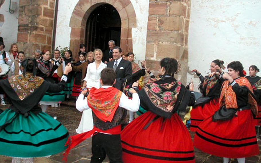 Costumed dancers circle newlyweds after they emerge from their wedding ceremony in the Hermitage of Our Lady of Allende in Ezcaray, Spain.
