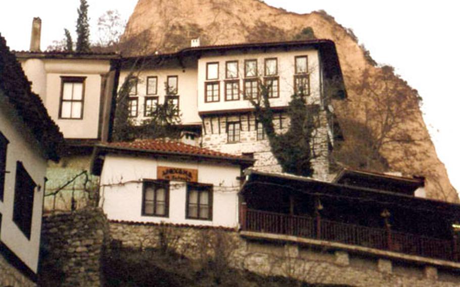 Sand cliffs known as the Melnik Pyramids form a backdrop for the old, white Revival houses of Melnik.