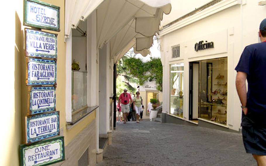 Small tile signs serve as navigation tools in the narrow streets of Capri town, pointing the way to shops, restaurants and hotels.
