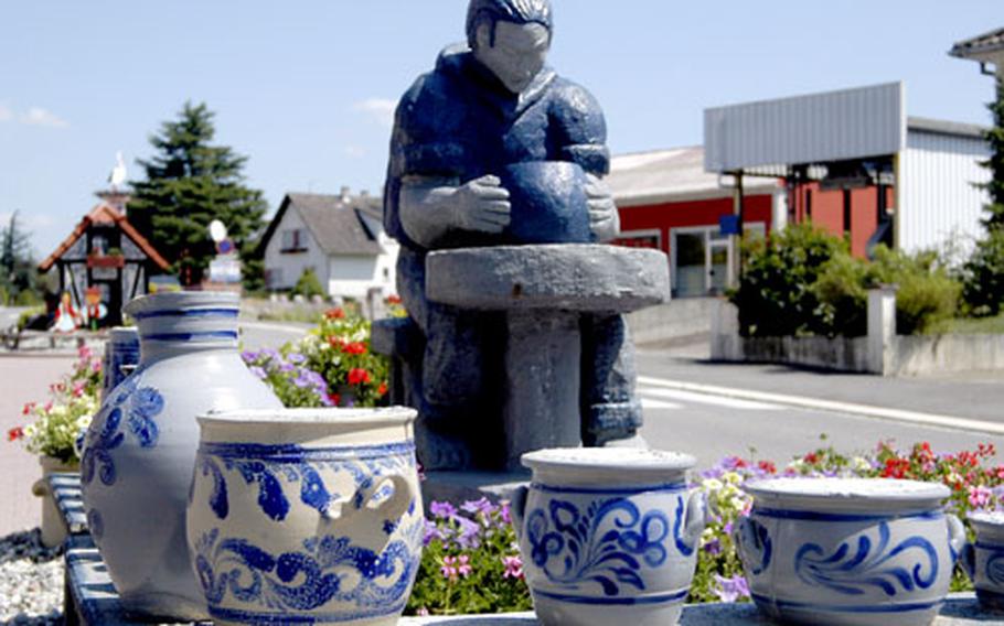 A statue of a potter, and the traditional gray-and-cobalt pottery, greet visitors when they enter Betschdorf, France, from the west.
