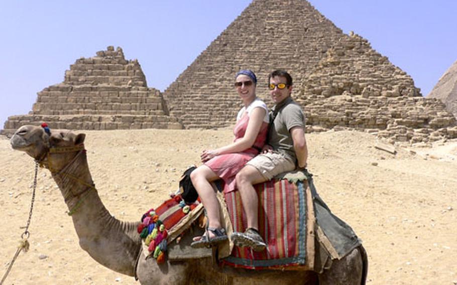 Anya Clark, a British tourist, and Stars and Stripes reporter Ben Murray sit astride Moses 2000, the camel, during their “semi-legal tour” of the backside of the pyramids at Giza.