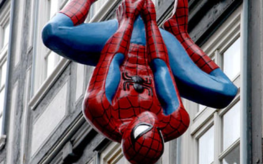 Spiderman, an advertisement for a comics and games shop, hangs in front of a half-timbered house in Marburg’s old town.