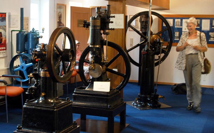 A visitor studies the first Otto motor displayed in the main room of the Nicolaus August Otto Museum in Holzhausen, Germany.