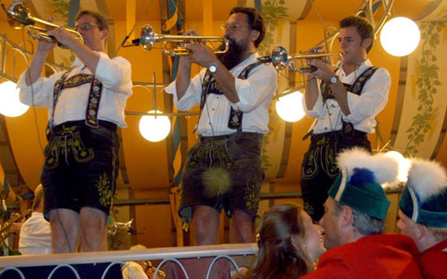 A couple steals a smooch as a band plays inside one of the 14 beer tents during the 2005 Oktoberfest in Munich, Germany.