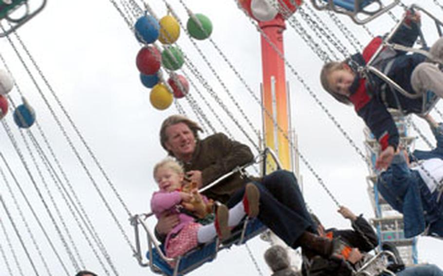 A father and daughter take a whirl on the swings at the 2005 Oktoberfest in Munich, Germany.