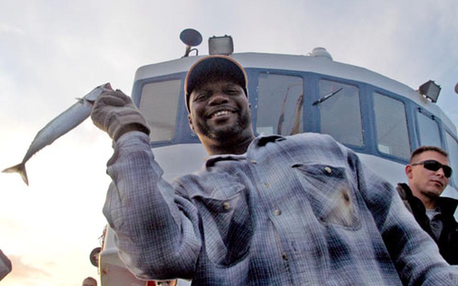 Winston Clement happily shows off the first catch of the day aboard the M.S. Maria.