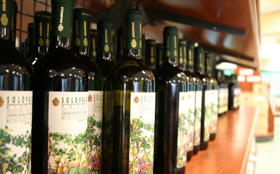Rows of wine bottles bearing the label of the Cantina Sociale di Solopaca line a shelf at the winery.