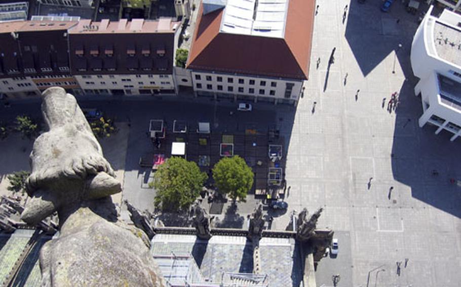 A few from the Ulm Münster&#39;s tower looks down at carved animals and statues jutting out from the cathedral.