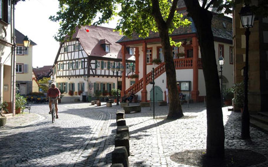 A cyclist passes by the old town hall, right, built in 1755, during a peaceful late afternoon in Freinsheim.
