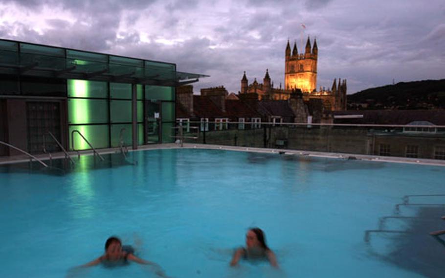 The rooftop pool at the Thermae Bath Spa in Bath, England, provides an illuminated view of the Bath Abbey and the darkening sky while you float comfortably in warm water.