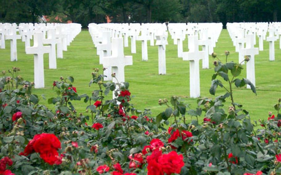 Groves of trees, grass and scarlet roses frame many of the 10,489 crosses and Stars of David that mark graves of fallen American veterans of World War II at the Lorraine American Cemetery in St. Avold, France.