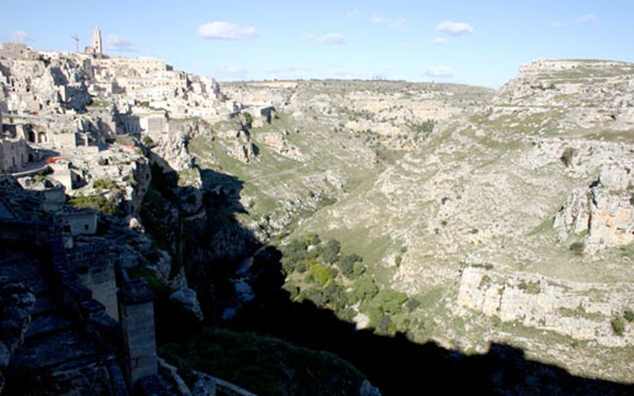 The Sasso Caveoso section of the ancient town of Matera is cut into and sits atop a steep ravine, offering a stunning view of the rocky hills and leading to the river at the bottom.