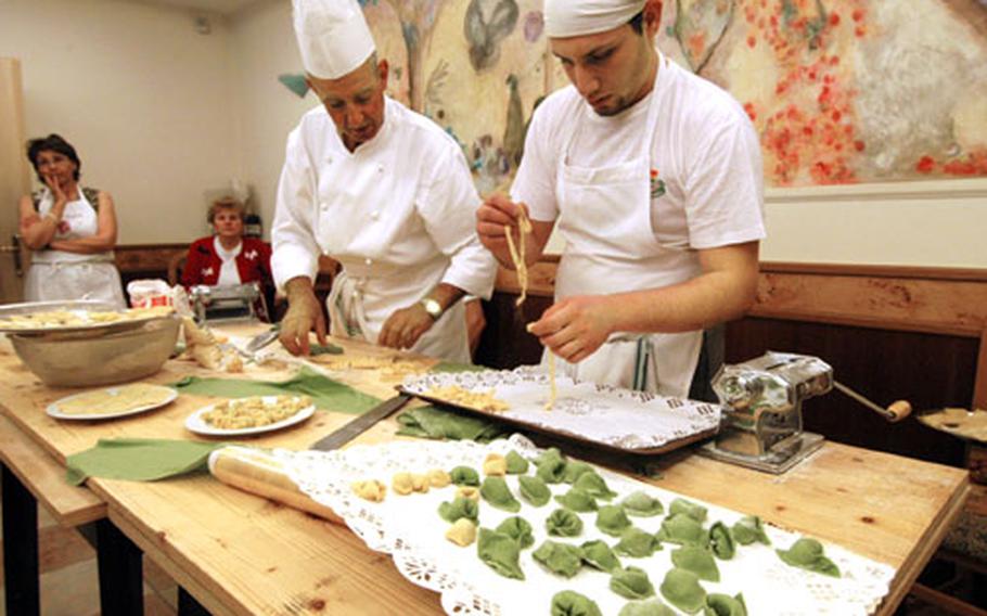 Chef Bruno Pederzolli and his assistant, Vladamir, prepare fresh fettuccine during a Gourmet Italia cooking class in May. In the foreground are tortellini made by students.