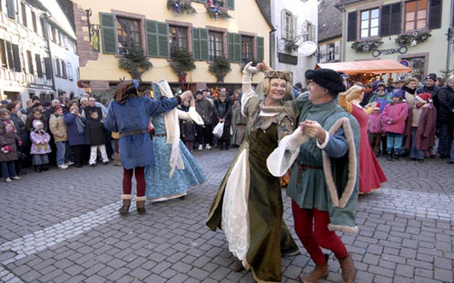 Dressed in medieval garb, dancers entertain visitors to the Ribeauville, France Christmas market, one with a medieval flair.