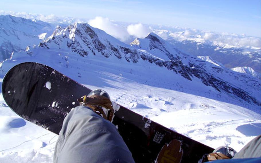 A snowboarder looks down at the mountaintops as he stands perched at the start of the black run, 10,000 feet up, at the Kitzsteinhorn ski area near Kaprun, Austria. The Kitzsteinhorn is an ideal spot for families because it offers runs suitable for beginners as well as more advanced skiers.