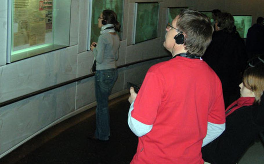 The way around the Mercedes-Benz Museum in Stuttgart, Germany, is down a spiral walkway, along which visitors can read about key moments in Mercedes-Benz and modern European history. They can also listen to a taped explanation of exhibits — available in eight languages — on a headset.