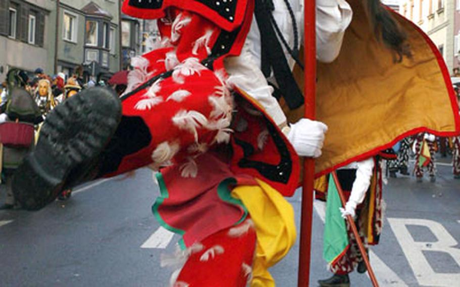 A carnival participant dressed in a Federahansel (Feather Jack) costume uses a stick to jump down the street during the traditional Narrensprung (Fools Jump) in Rottweil, Germany, in 2006.
