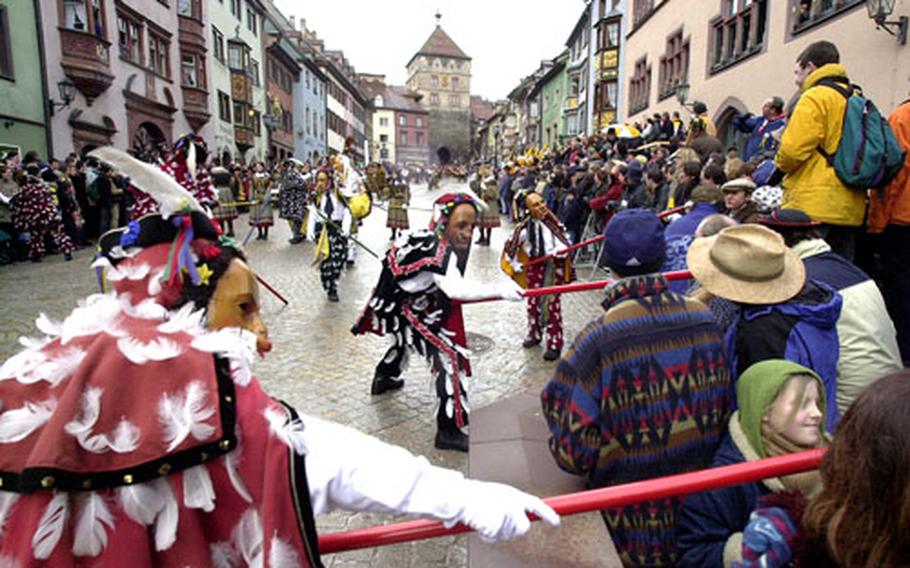 A group of "Federahannes", one of the figures of the "Narrensprung" ("Fools Jump") in Rottweil tease spectators with the calv&#39;s tail at the end of their pole. The event takes place every Rose Monday at 8 a.m. and is repeated on Fat Tuesday.