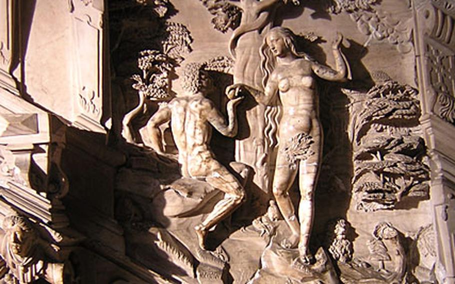 A closeup of the carvings on the pulpit inside the Magdeburg cathedral shows Adam accepting an apple from Eve.