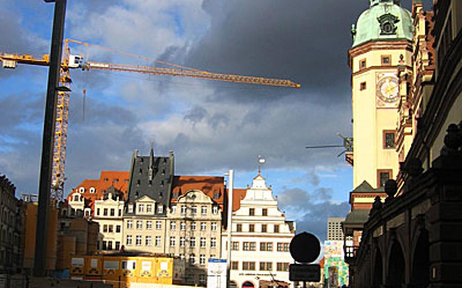 A sunset adds some color to the old and new of Leipzig. A crane used for new construction or renovation work stands amid buildings in the old town.
