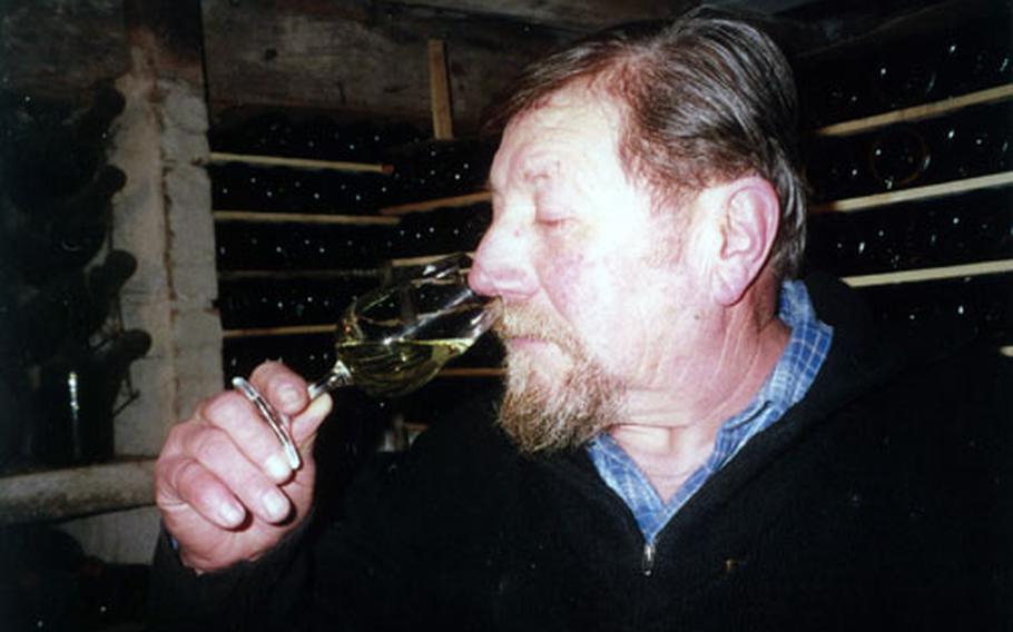 Lucien "Bacchus" Aviet tests the nose of one of his Jura wines. He produces 25,000 bottles of wine per year, a mixture of white and red.