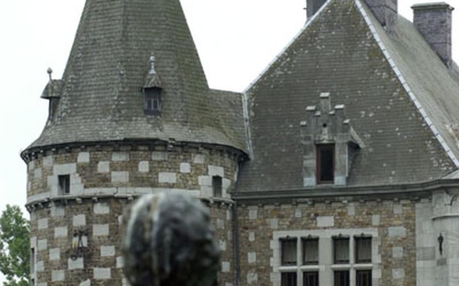 A garden statue peers at Jehay Castle in Amay, Belgium.
