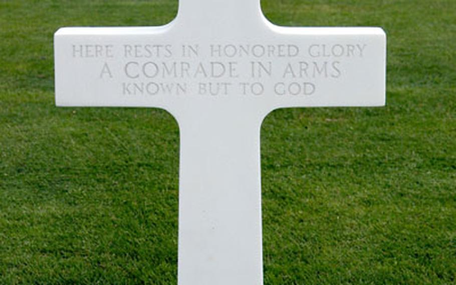 A cross reading "Here rests in honored glory a comrade in arms known but to God" marks the grave of an unidentified American service member at Netherlands American Cemetery at Margraten, Netherlands. 106 of the 8,301 American war dead buried there are unknowns.