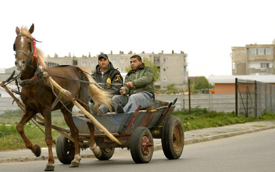 Local men drive by in a typical horse drawn trailer with truck tires in the city of Mangalia. With a median income of about $8,800, parts of each city in Romania reveal a reliance on the old way of doing things.