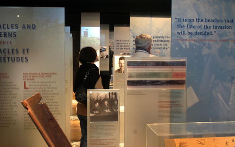 Rows of free-standing displays at the Normandy American Cemetery&#39;s new visitor center encapsulate anecdotes, equipment, maps and memorabilia that visitors can walk among as they learn some of the personal stories of troops who participated in the Allied invasion of Normandy.
