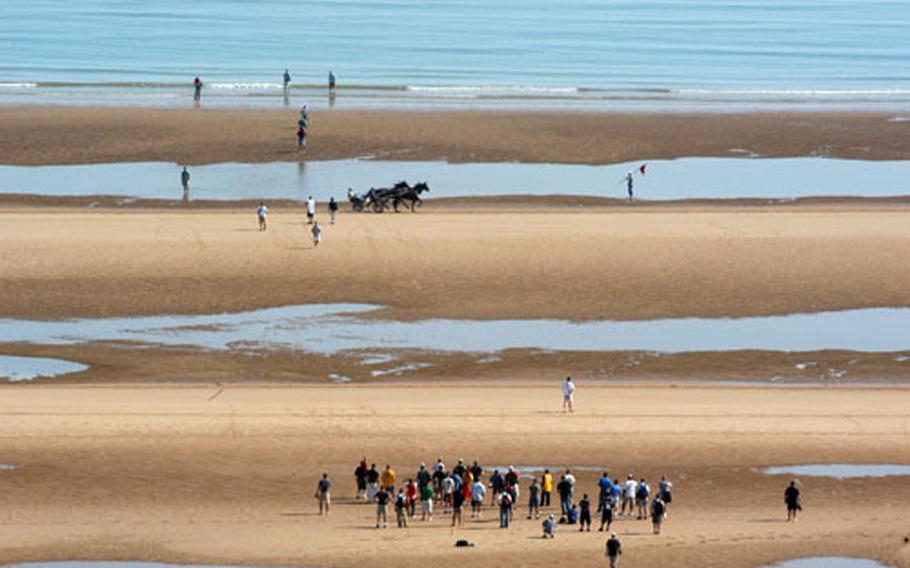 Tourists visiting Omaha Beach in early morning when the tide is out can watch race horses train or wade in the surf.