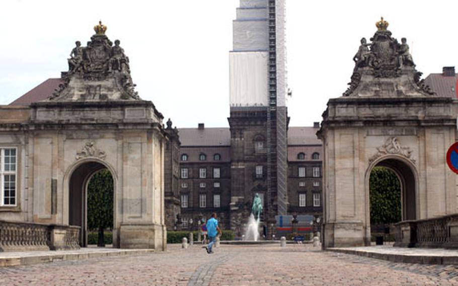 One of the entrances to the Slotsholmen in Copenhagen, Denmark, shows the under-renovation tower of the Christiansborg Palace in the background.