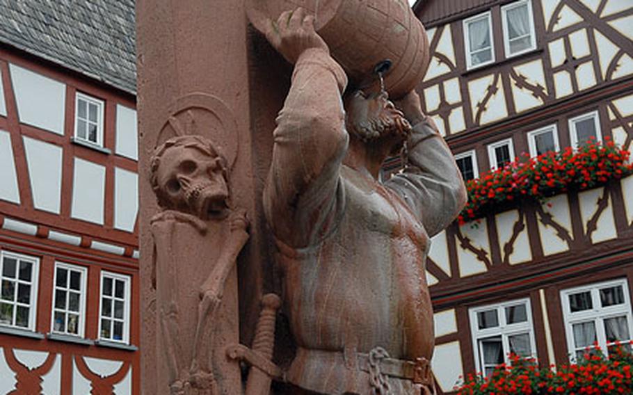 This 1985 statue of wine-drinking, knight-turned- city manager Friedrich von Hattstein is part of a fountain in a Limburg square. In the background are two of the town's many half-timbered houses.