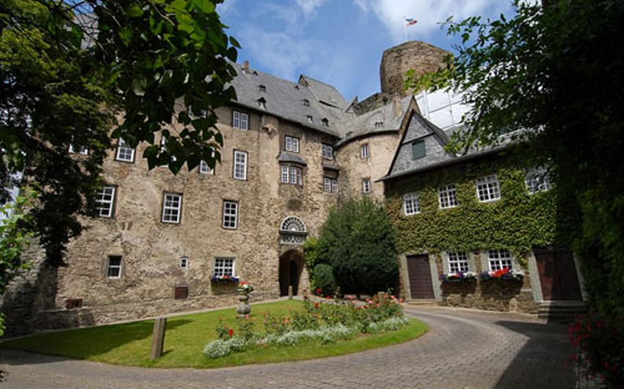Runkel Castle&#39;s outer courtyard, with the center block and gate to the inner courtyard at center, and the castle keep towering above.